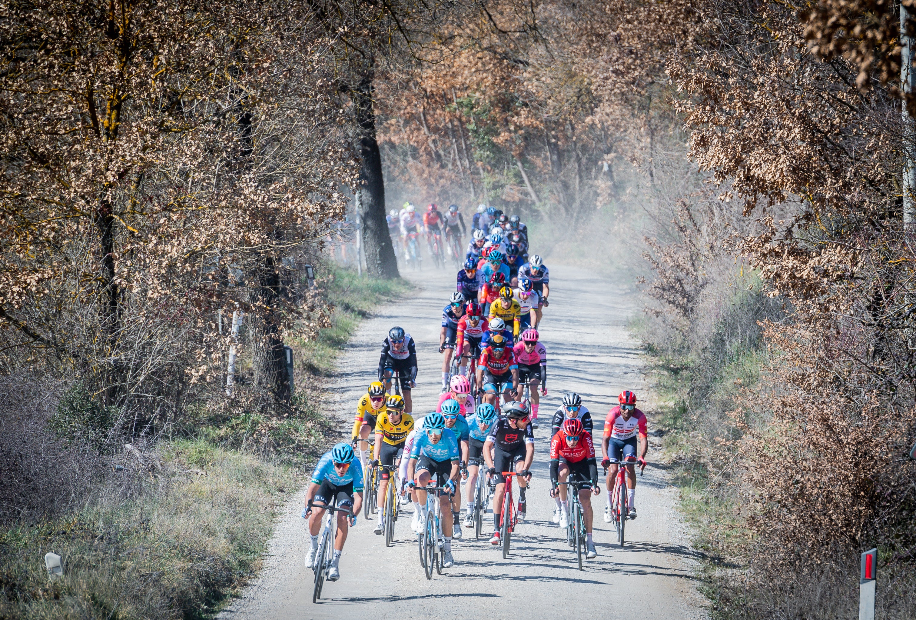 The peloton attacking on the white roads of Tuscany