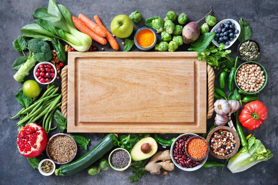 A choppingboard surrounded by vegetables