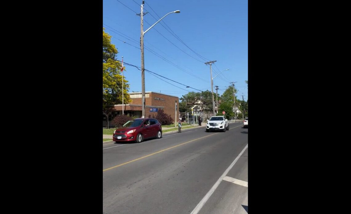 A kid riding out of a bike lane to avoid a car