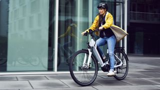 A women rides an e-bike through a city