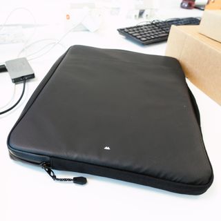 A black laptop case sits on a white desktop
