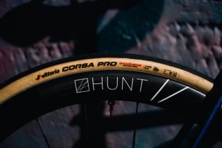 A darkened image showing the side-on angle of the Corsa Pro tyre mounted to a Hunt wheel, with the cotton fibres of the casing visible