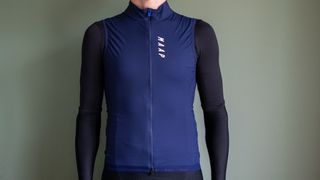 A man wearing a blue MAAP Draft gilet with black jersey and arm warmers