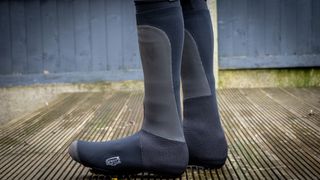 A image of a cyclist wearing Spatz Pro Stealth overshoes on wooden decking