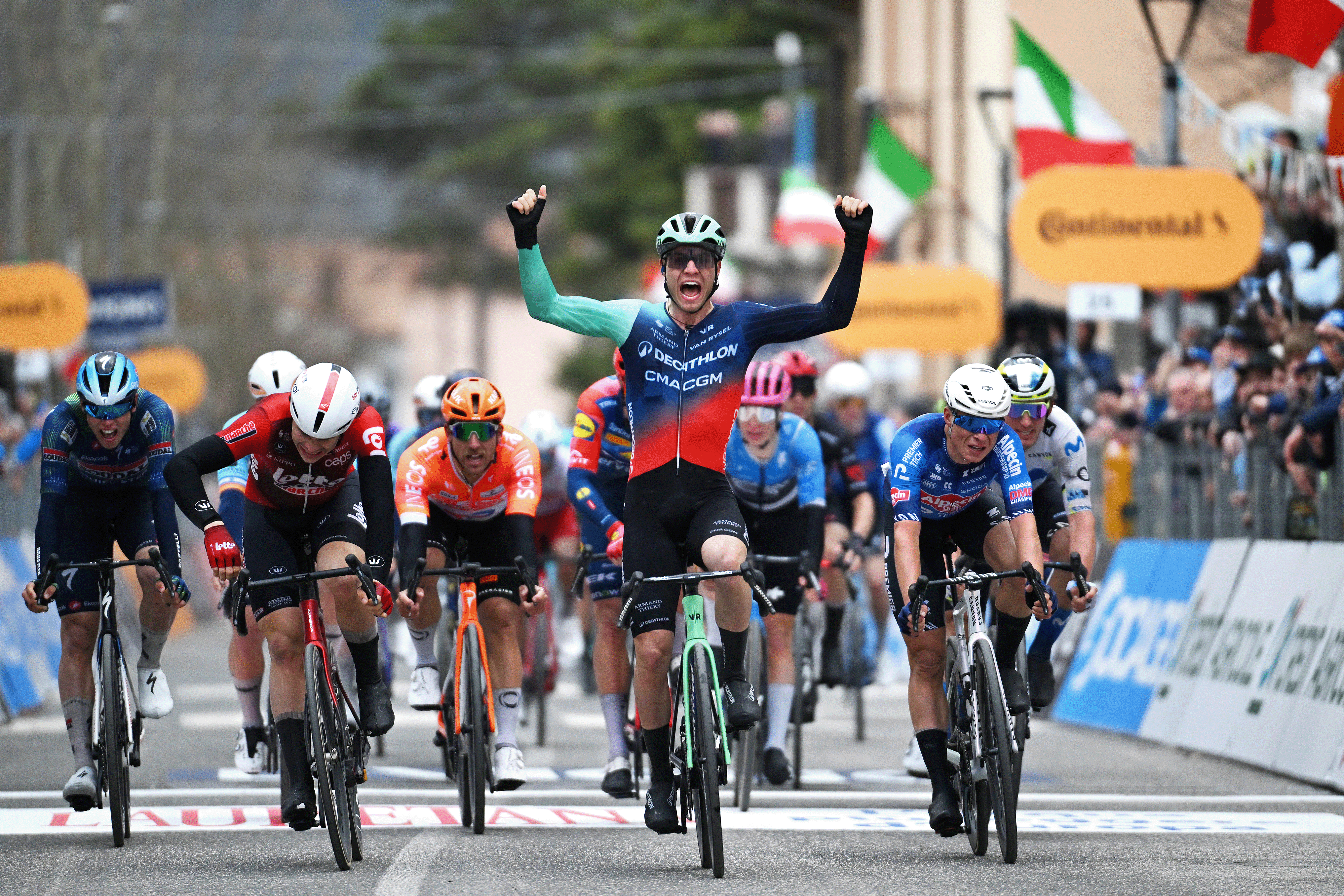 Lund Andresen celebrates with both arms raised ahead of a group of sprinters